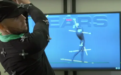 Golfer wearing motion-capture markers with a GEARS avatar on a monitor